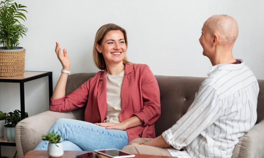 Eine Krebspatientin sitzt beim Psychoonkologischen Gespräch zusammen mit einer Therapeutin.