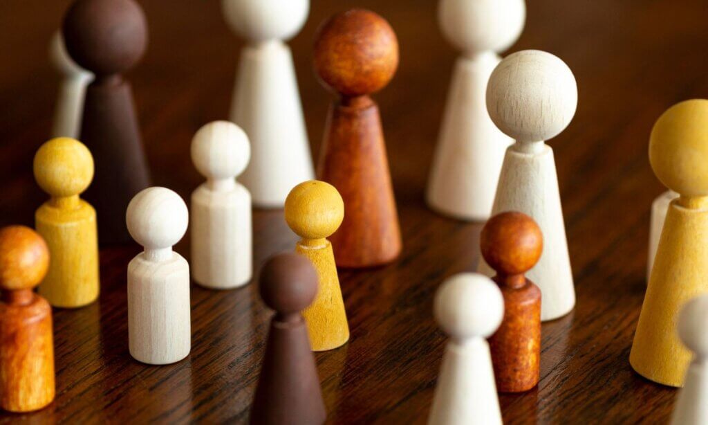 Spielfiguren unterschiedlicherGröße und Farbe stehen für das Thema soziale Ungerechtigkeit. 