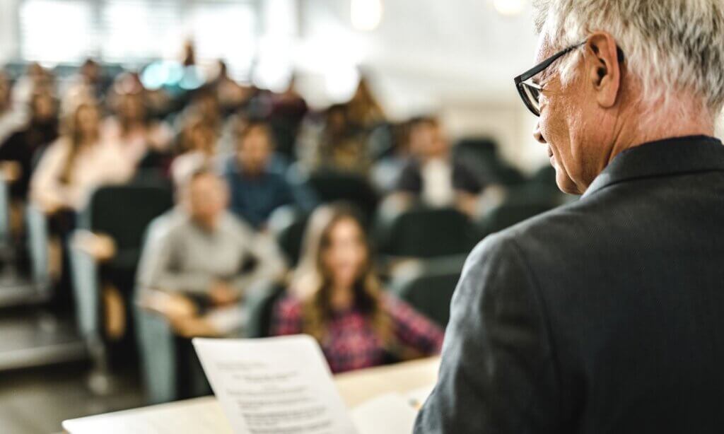 Ein Vortragender spricht zu einem Saal voll TherapeutInnen.
