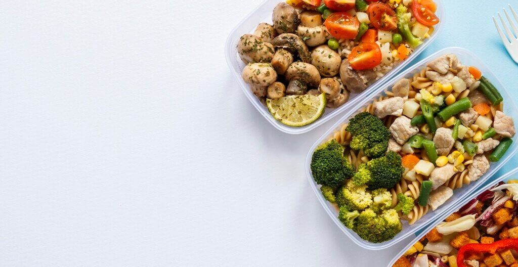 Glasdosen mit vorbereitetem Essen stehen bereit um in die Arbeit mitgenommen zu werden.