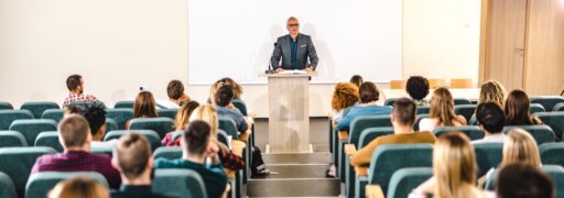 Eine Gruppe TherapeutInnen blickt auf einen Vortragenden auf einem Podium.