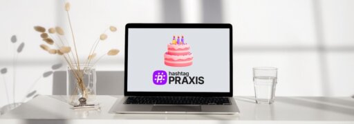 Ein Laptop auf dem passend zum ersten Geburtstag von hashtagPRAXIS eine Geburtstagstorte und das Logo des Magazins zu sehen ist.