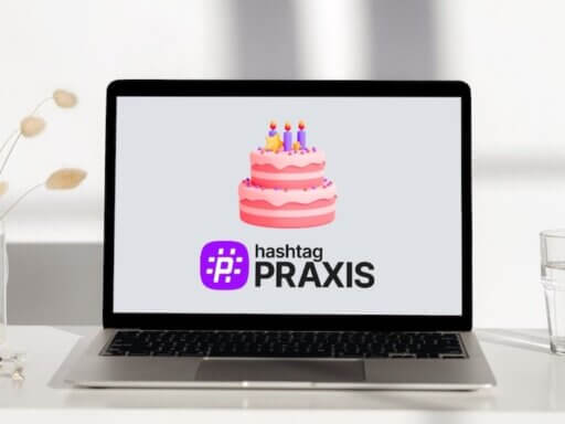 Ein Laptop auf dem passend zum ersten Geburtstag von hashtagPRAXIS eine Geburtstagstorte und das Logo des Magazins zu sehen ist.