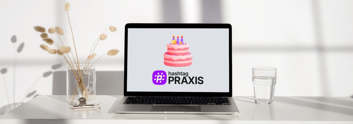 Ein Laptop auf dem passend zum ersten Geburtstag von hashtagPRAXIS eine Geburtstagstorte und das Logo des Magazins zu sehen ist.
