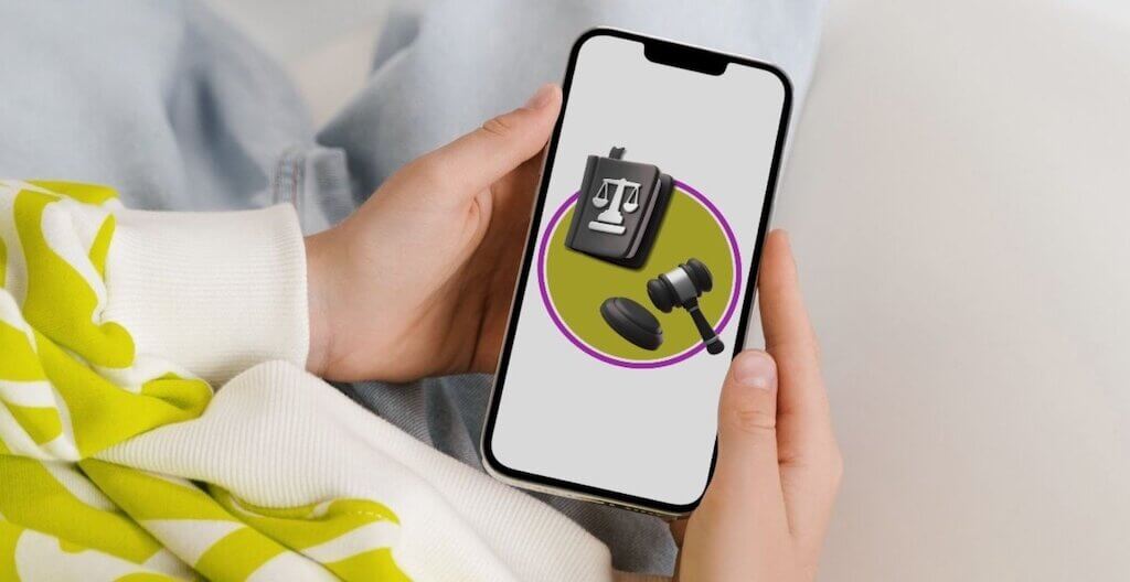 Eine Person hält ein Smartphone auf der ein Logo mit Gesetzbuch und Richter-Hammer zu sehen ist – sinnbildlich für die juristischen Tools, die genutzt werden können.
