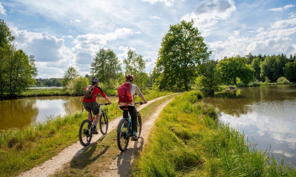 Zwei Personen bewegen sich nachhaltig durch Bayern – in diesem Fall auf Fahrrädern.