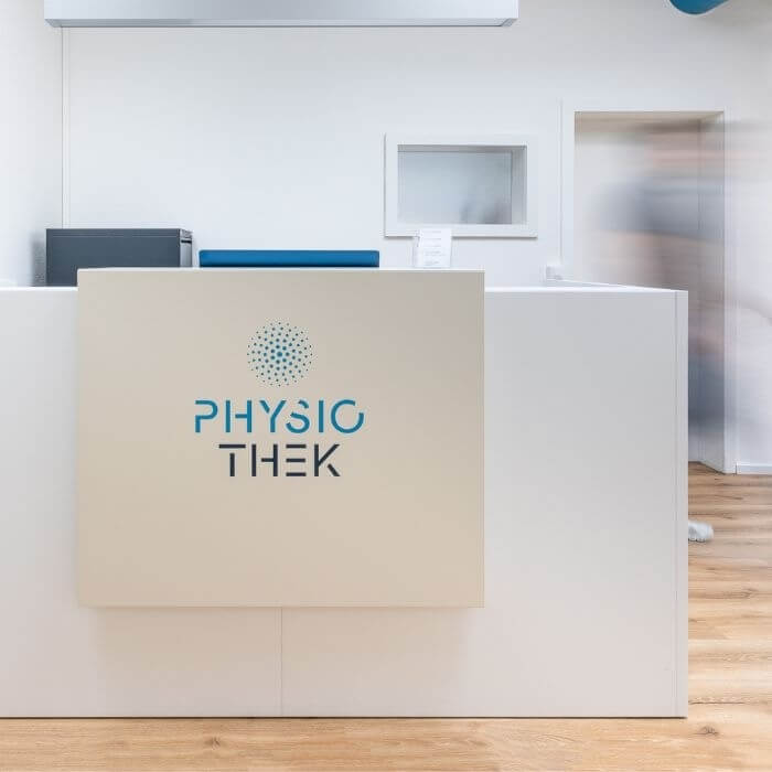 Die Empfangstheke der Physiothek in Basel – mit prägnant platziertem Logo.
