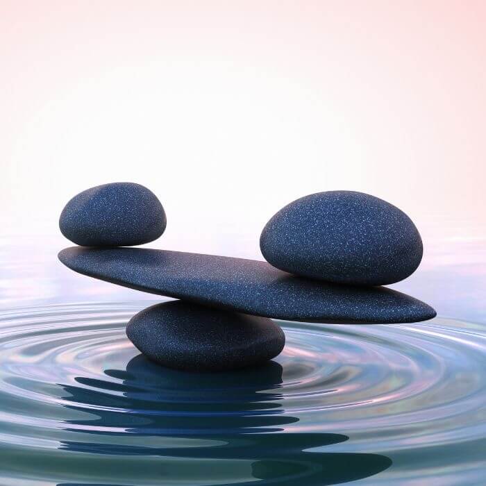 Steine, die auf dem Wasser liegend die Balance halten.