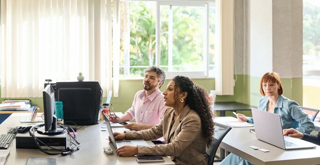 Eine Vortragende erzählt einer Gruppe von sechs Personen mehr zu einem Gesundheitsthema.