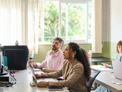 Eine Vortragende erzählt einer Gruppe von sechs Personen mehr zu einem Gesundheitsthema.
