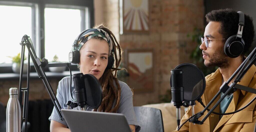 Ein Mann und eine Frau sprechen eine Podcast-Folge ein.