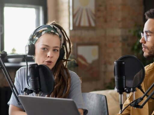 Ein Mann und eine Frau sprechen eine Podcast-Folge ein.