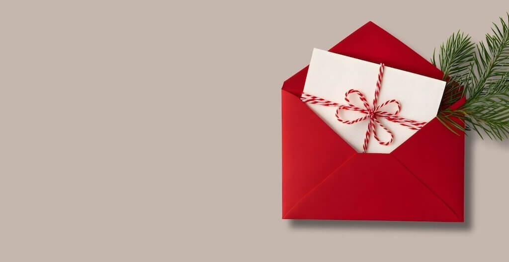 Ein weihnachtliches Briefkuvert mit einem Tannezweig – wir geben Tipps für die Weihnachtspost, die TherapeutInnen an ihre PatientInnen versenden können.